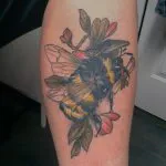 A photo of a bumble bee tattoo on the calf, before any laser tattoo removal treatment.