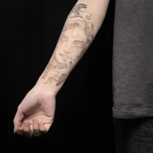 A photo of the snake and female face tattoo on the forearm, after 1 treatment and 5 weeks later