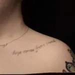 A photo of the collarbone script after 1 laser tattoo removal treatment, 7 weeks later.