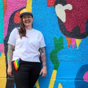 A photo of Madi Rawson in front of the mural by Jean Paul Langlois