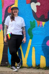 A photo of Madi Rawson in front of the mural by Jean Paul Langlois