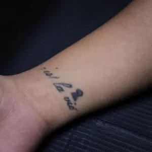 A photo of the C'est La Vie script tattoo before any laser tattoo removal treatments