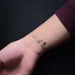 A photo of the script tattoo after one laser tattoo removal treatment, 10 weeks later